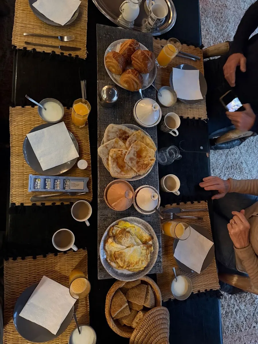 A homemade breakfast spread: msemen, jams, fresh juice and mint tea