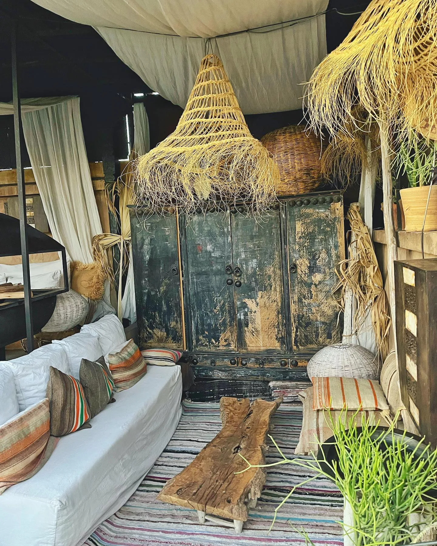 The draped rooftop lounge of Riad Lola: raffia pendants, timeworn cabinet, white linen sofa