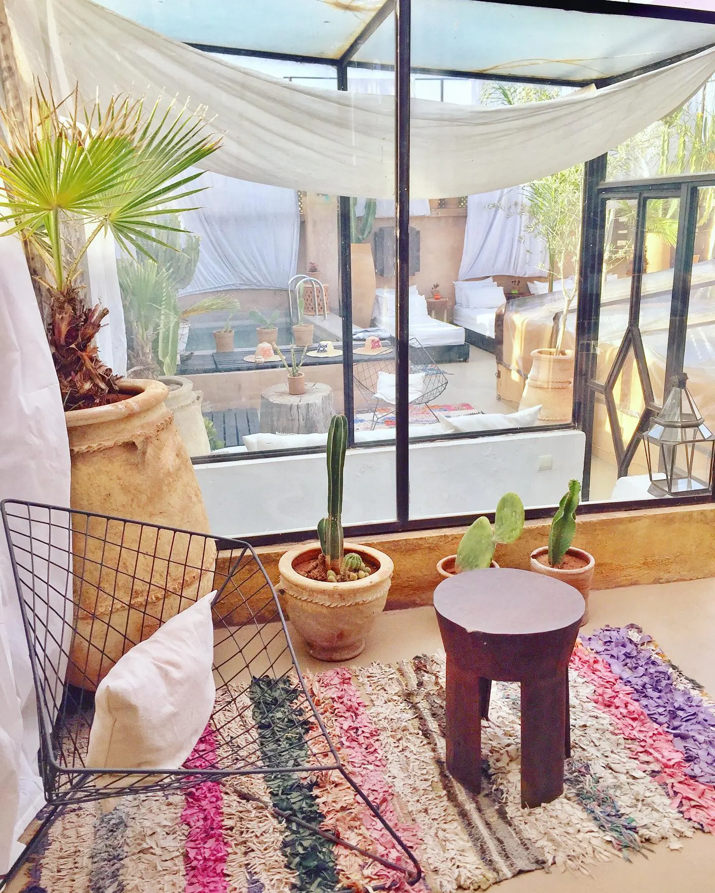 A daybed dressed in white by the terrace pots