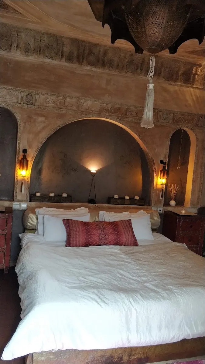 A bed set into an arched alcove with a red cushion